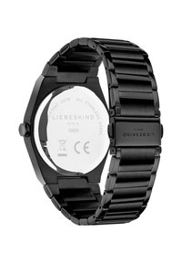 Orologio in acciaio inossidabile nero con cassa ottagonale, bracciale a maglie e fondello trasparente con dettagli del marchio e informazioni sulla resistenza all'acqua incisi.