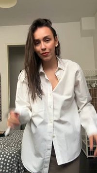 Weißes, übergroßes Button-Down-Hemd mit Kragen, ausgestattet mit einem oberen Knopf und lockeren Ärmeln, getragen über einem braunen Rock.