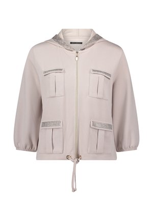 Jasnobeżowa bluza z kapturem zapinana na zamek, z czterema przednimi kieszeniami z patką, ściągaczem na dole, rękawami do łokcia oraz siateczkowymi wstawkami na kieszeniach i kapturze.