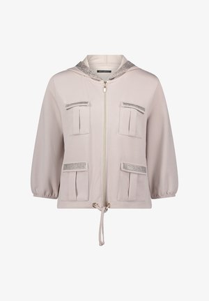 Lichtbeige capuchonvest met ritssluiting, vier klepzakken aan de voorkant, trekkoordzoom, driekwart mouwen en mesh afwerking op zakken en capuchon.