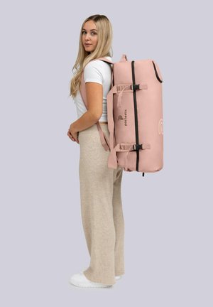 Sac de sport cylindrique rose avec des accents noirs et des sangles réglables, fabriqué en matériau durable, avec un logo et une poche latérale.