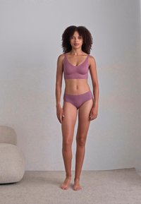 Light purple seamless bralette and high-waisted underwear set. Textured fabric with adjustable straps and minimalistic design.