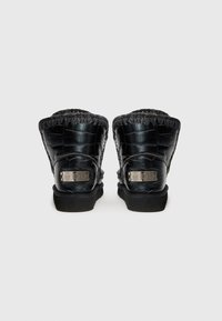 Botine negre din piele cu finisaj texturat și detalii cusute. Prezintă accente metalice cu logo în zona călcâiului și o talpă robustă din cauciuc.