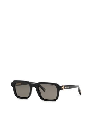 Lunettes de soleil rectangulaires noires avec verres foncés et accents dorés sur les branches, marquées "Chopard" sur le côté.