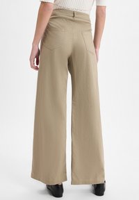 Khaki wijde pijpenbroek van een gestructureerde stof, met een hoge taille, achterzakken en een rechte snit. De zoom is licht uitlopend.