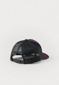 Cappello da baseball con parte anteriore in tessuto bordeaux e retro in rete nera, fascia regolabile stesa su una superficie bianca.