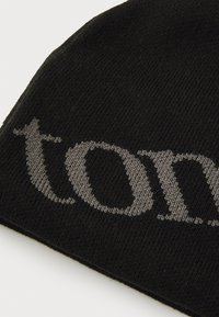 Sort strikket beanie med et iøjnefaldende gråt tekstmønster. Teksturen er glat og strækbar, med et tætsiddende design for varme.
