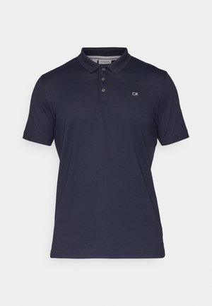 Tumesinise värviga polo särk, valmistatud siledast puuvillast, klassikalise kraega, kolmeknöppliga ja väikese tikitud CK logoga.