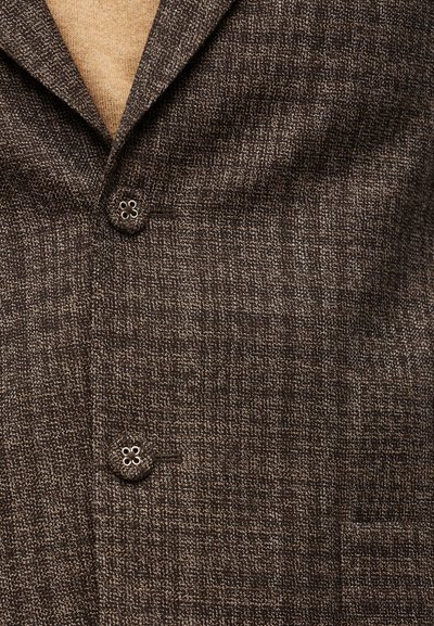 Καφέ σακάκι με υφή, διαθέτει γιακά με εγκοπές, δύο κουμπιά και ένα τσέπη ραμμένη, κατασκευασμένο από υφασμένο ύφασμα με διακριτικό μοτίβο.