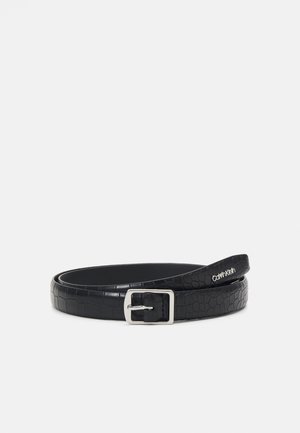 Ceinture en cuir noir à texture crocodile, boucle rectangulaire argentée, avec petit logo Calvin Klein près de l'extrémité, enroulée sur un fond blanc.