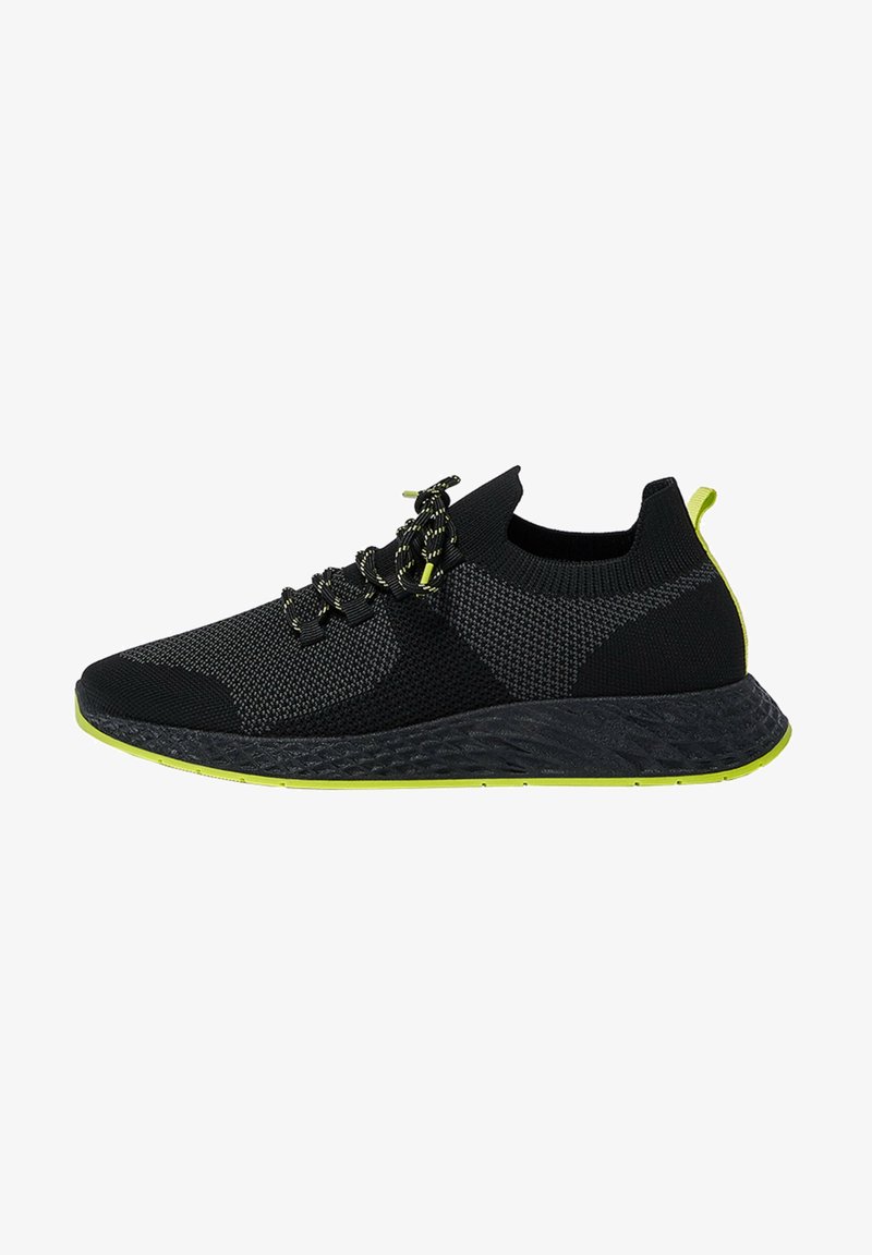 Baskets de sport noires et grises avec semelle noire et accents vert néon, dessus tricoté, design lacé et languette à l'arrière.