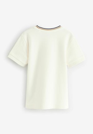 Koszulka krótki rękaw w kolorze kremowym, wykonana z fakturowanej tkaniny, z prążkowanym kołnierzykiem w czerni i złotych akcentach.