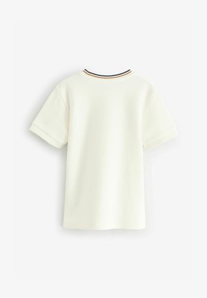 Koszulka krótki rękaw w kolorze kremowym, wykonana z fakturowanej tkaniny, z prążkowanym kołnierzykiem w czerni i złotych akcentach.