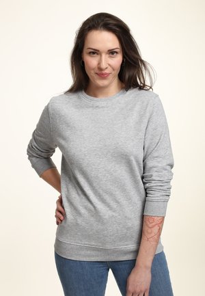 Felpa grigia con collo a giro, polsini e orlo ribattuti. Presenta una texture morbida e una vestibilità comoda, abbinata a jeans blu.
