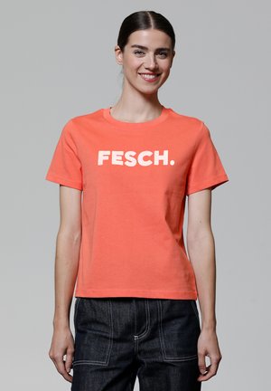 Koraalkleurig T-shirt met korte mouwen met een witte "FESCH." graphic op de voorkant. Gemaakt van katoen, met een ronde hals en een ontspannen pasvorm.