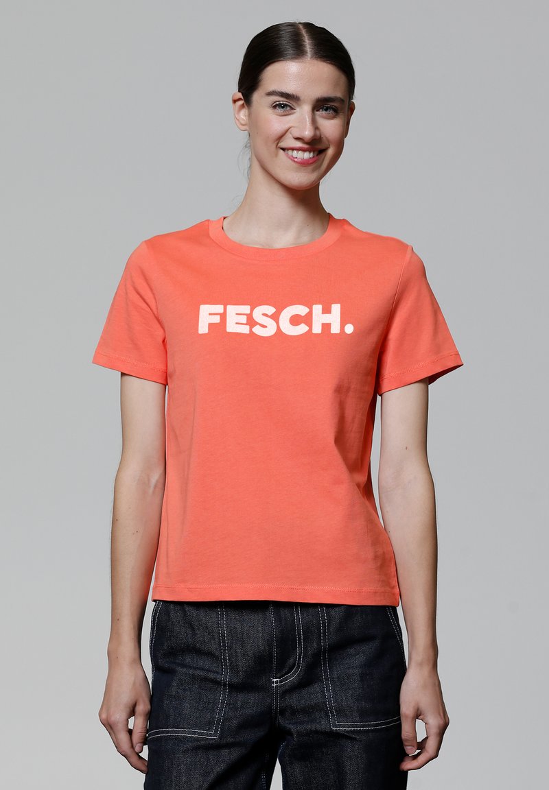 Koraalkleurig T-shirt met korte mouwen met een witte "FESCH." graphic op de voorkant. Gemaakt van katoen, met een ronde hals en een ontspannen pasvorm.