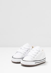 Baskets en toile blanches avec semelles en caoutchouc, dotées d'une fermeture à lacets et d'accents en bande noire. Bout rond et semelle texturée pour une meilleure adhérence.