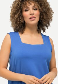Top senza maniche blu con scollo quadrato, realizzato in tessuto liscio. Presenta una vestibilità rilassata e un design minimale, adatto per un look casual.