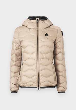 Chaqueta de plumas beige con un patrón acolchado, cierre de cremallera y capucha. Presenta detalles en negro en los puños y el cuello. Material ligero.
