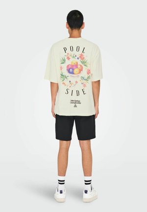 Camiseta blanca de manga corta con un gráfico de un tazón de bolas de billar de colores. El texto dice "POOL SIDE" en negro con acentos florales.