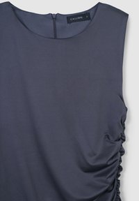 Top grigio senza maniche con scollatura rotonda, caratterizzato da arricciature laterali per aggiungere texture e chiusura con cerniera posteriore; realizzato in un tessuto morbido e liscio.