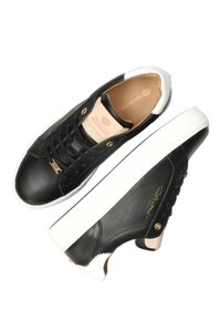 Czarne skórzane sneakersy z białymi akcentami, płaską podeszwą, okrągłym noskiem i złotymi detalami. Charakteryzują się gładką teksturą i logo na języku.