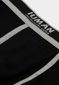 Boxer ajustados negros de tela texturizada. Cuenta con una cinturilla gris con la marca "IUMAN" y una franja gris en contraste en la parte frontal.