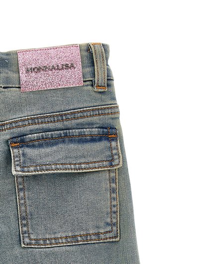 Jeans in denim con una lavatura azzurro chiaro. Le caratteristiche includono un'etichetta in glitter rosa sulla vita con la scritta "MONNALISA" e una tasca sul retro. Texture sfilacciata visibile.