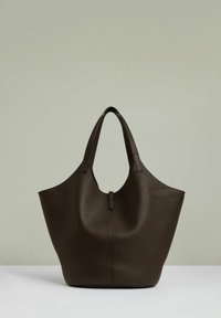 Brązowa skórzana torba tote z szerokim otwarciem, zaokrąglonym topem i dwoma krótkimi uchwytami; charakteryzuje się teksturowanym wykończeniem i minimalistycznym designem.