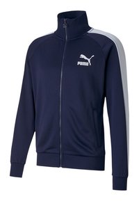 Námořnická modrá zipová bunda vyrobená z měkké látky, zdobená bílými bočními akcenty a výrazným bílým logem Puma na levé hrudi.