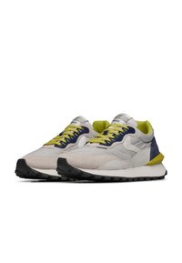 Sneaker grigie chiare in materiali scamosciati e mesh, con accenti blu navy e verde lime, punta arrotondata e suola in gomma nera testurizzata.