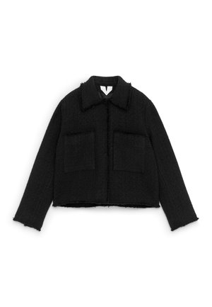 Czarna, teksturowana kurtka z wełny z długimi rękawami, szerokim kołnierzem, przednimi kieszeniami oraz surowym wykończeniem na dole i mankietach, rozłożona na płasko na białym tle.