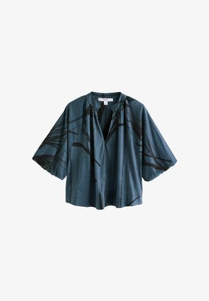 Blusa a maniche corte in tessuto turchese con motivi floreali neri, vestibilità comoda, senza collo e tessuto morbido e liscio.