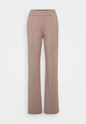 Bukser laget av myk, lys brun stoff med vid bendesign. Har en elastisk midjebånd og to fremre pregede linjer.