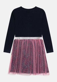 Abito lungo a maniche nella tonalità navy con una cintura luccicante argento e una gonna in tulle rosa caratterizzata da un motivo di stelle nei toni del rosso e blu.