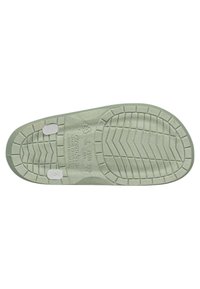 Suola in gomma di colore verde chiaro con un motivo di battistrada testurizzato. Le caratteristiche includono dettagli del modello in rilievo e accenti circolari bianchi.