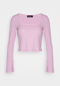 Rosa langärmliges Crop-Top mit quadratischem Ausschnitt, aus weichem Material gefertigt, mit Schlitzen an den Ärmeln für zusätzlichen Detail.