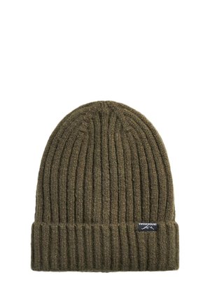 Bonnet en maille côtelée vert olive avec revers plié et petite étiquette de marque noire portant la mention "Swedemount" sur le revers.