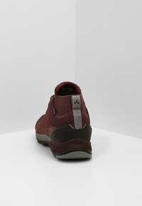 Röd och brun vandringsko med meshuppdelning, vadderad krage och grå accenter. Tjock gummisula för grepp och hållbarhet.