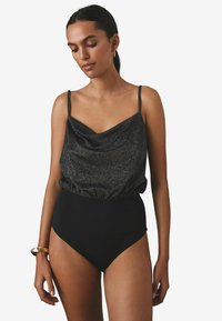 Maillot de bain noir taille haute avec un buste métallique brillant drapé, doté de fines bretelles ajustables pour un ajustement parfait et une texture lisse.