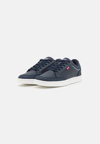 Navy blue sneakers made of textured synthetic material, white sole, flat lace-up design, with small logo and perforated accents on sides.