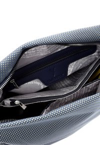 Interno di una borsa in tessuto intrecciato blu navy e azzurro con molteplici tasche, inclusa una sezione con zip e un patch con logo. Fodera liscia con un motivo testuale.
