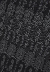 Textil negro con un patrón repetido de formas curvas, elaborado con un tejido suave y ligeramente texturizado, que muestra diferentes tonos de negro.