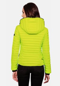 Neon green puffer jacket with a hood, featuring a quilted design and elastic cuffs, paired with black pants.