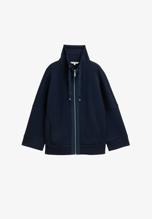 Marineblauwe zip-up jack met hoge kraag, trekkoorden, lange mouwen en zijzakken, weergegeven op een witte achtergrond.