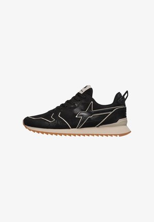 Basket de sport noire et beige avec lacets à l'avant, motif étoile sur le côté et semelle en gomme rainurée, vue de profil extérieur.