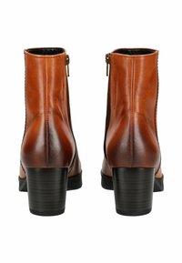 Bottines en cuir marron avec une finition lisse, dotées d'une fermeture éclair sur le côté et d'un talon épais noir. Le design comprend des détails de coutures.