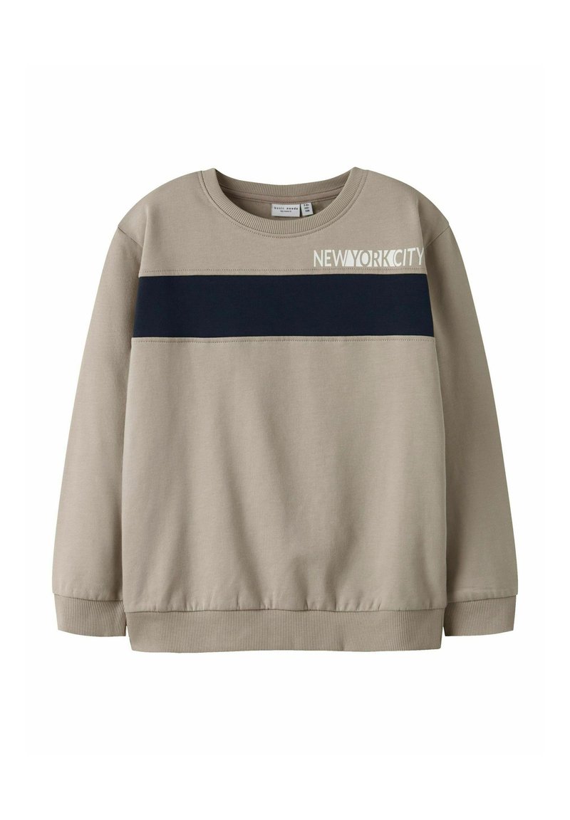 Beige sweatshirt met een ronde halslijn, marineblauwe horizontale streep en de tekst "NEWYORKCITY" in het wit. Zachte stof met ribgebreide manchetten en zoom.