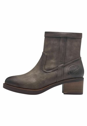 Bottine marron avec une finition en cuir lisse, des accents cousus, des panneaux élastiques sur les côtés et un talon block. Logo embossé sur le côté.