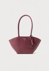 Geantă de mână din piele bordo, cu formă triunghiulară, prevăzută cu două mânere, un logo auriu și un pandantiv în formă de inimă atașat.
